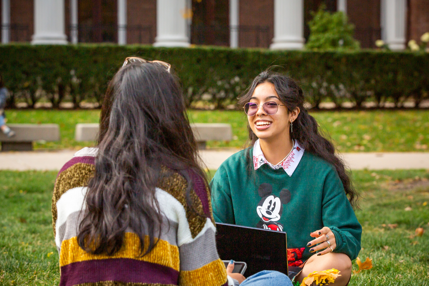 two students talking to each other and smiling